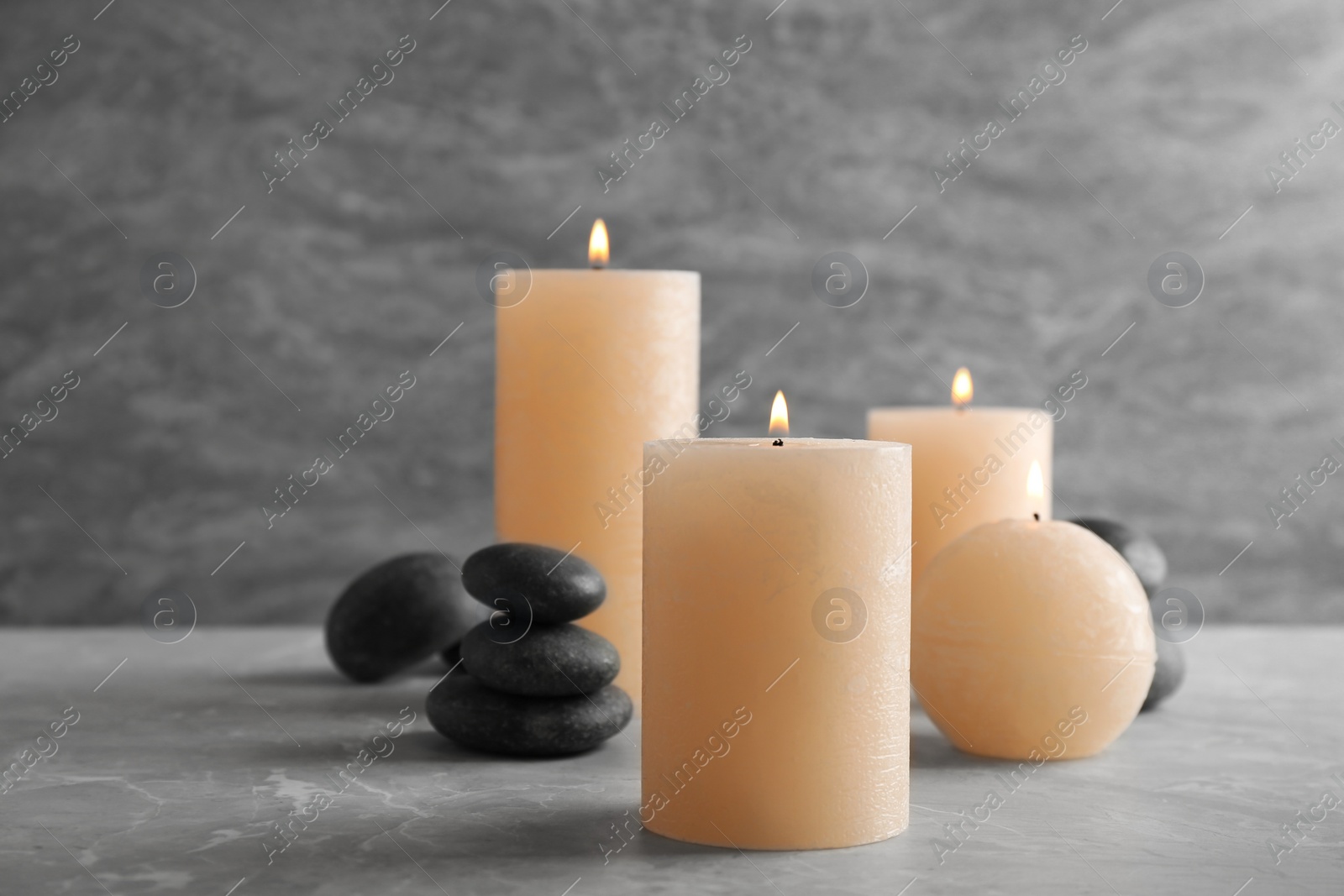 Photo of Burning candles and spa stones on table. Space for text