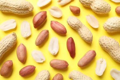 Photo of Fresh peanuts on yellow background, flat lay