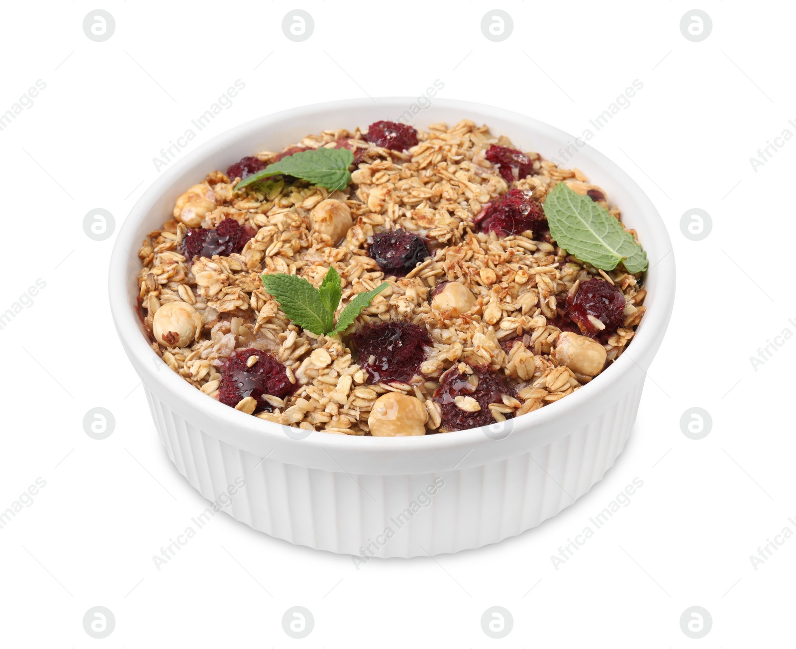 Photo of Tasty baked oatmeal with berries and nuts in bowl isolated on white
