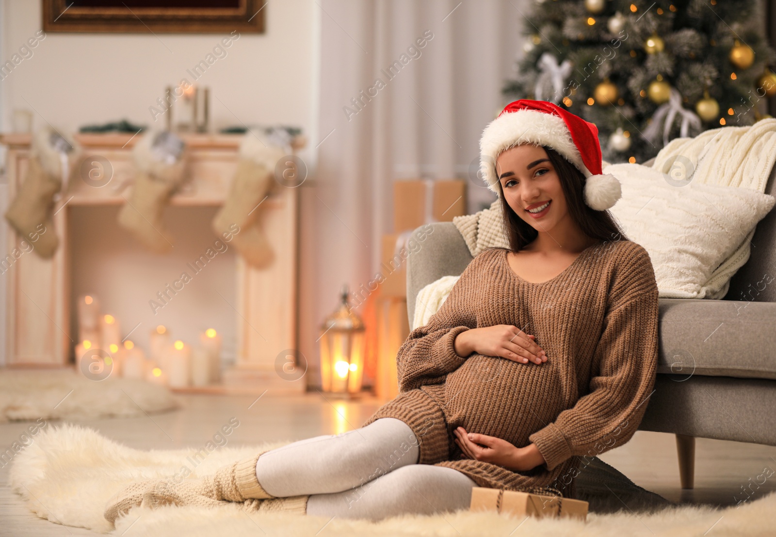 Photo of Happy pregnant woman with Christmas gift box at home. Expecting baby