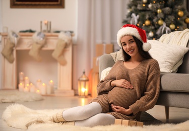 Photo of Happy pregnant woman with Christmas gift box at home. Expecting baby