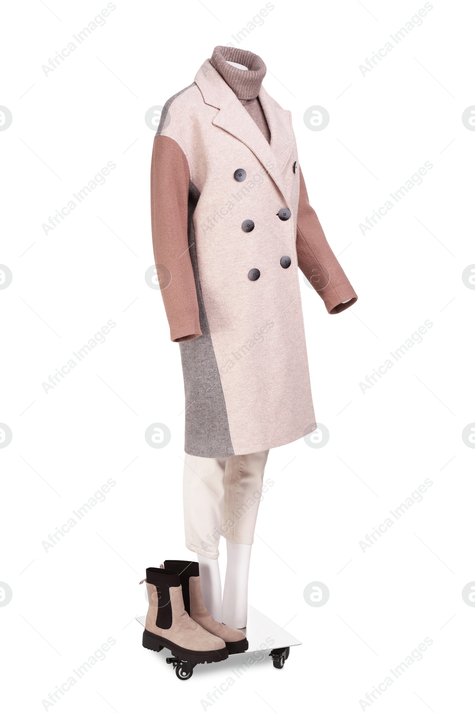 Photo of Female mannequin with boots dressed in stylish coat, sweater and pants isolated on white