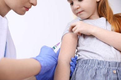 Little girl receiving chickenpox vaccination on white background, closeup. Varicella virus prevention