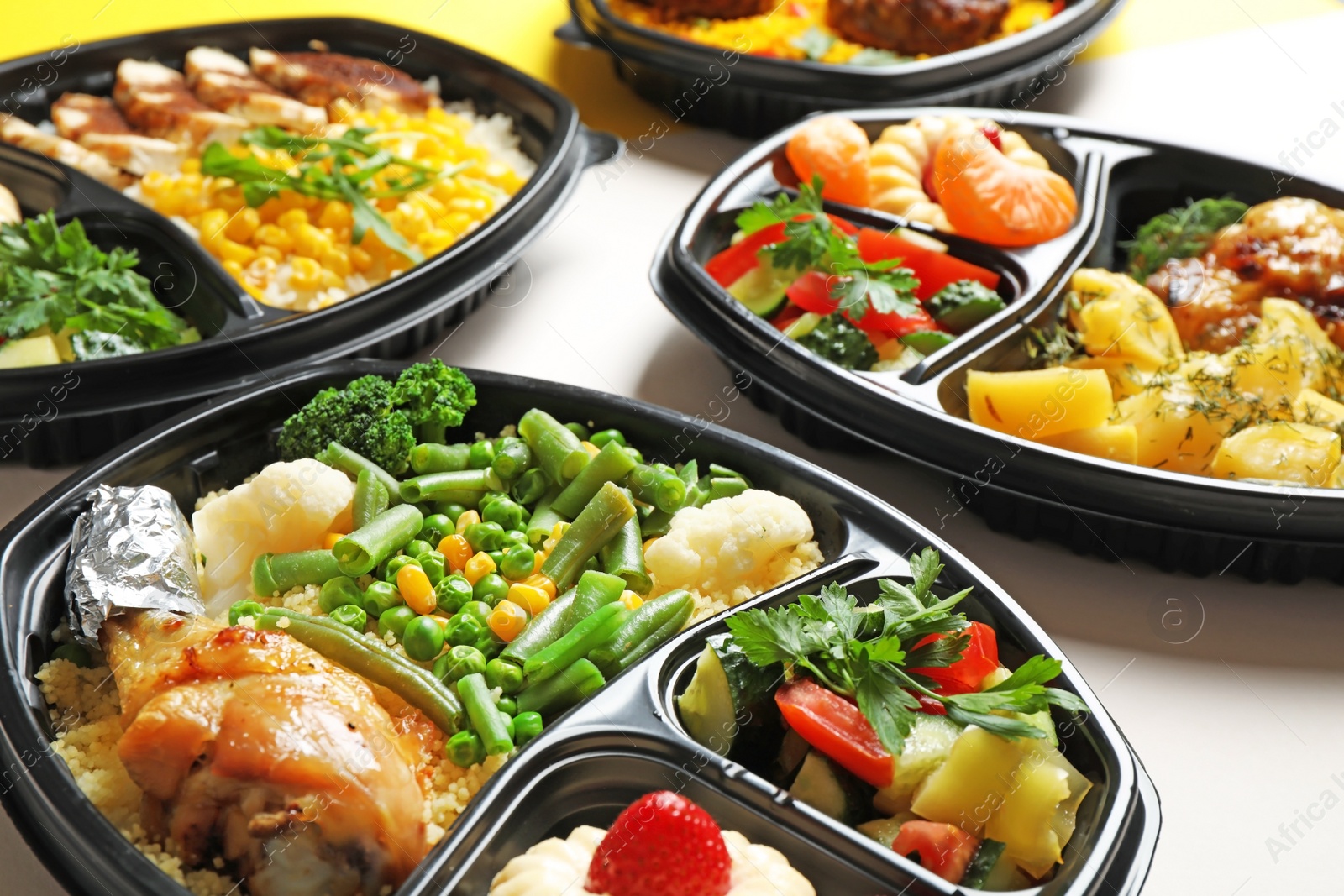 Photo of Lunchboxes with different meals on white table, closeup. Healthy food delivery