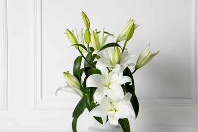 Photo of Beautiful bouquet of lily flowers near white wall