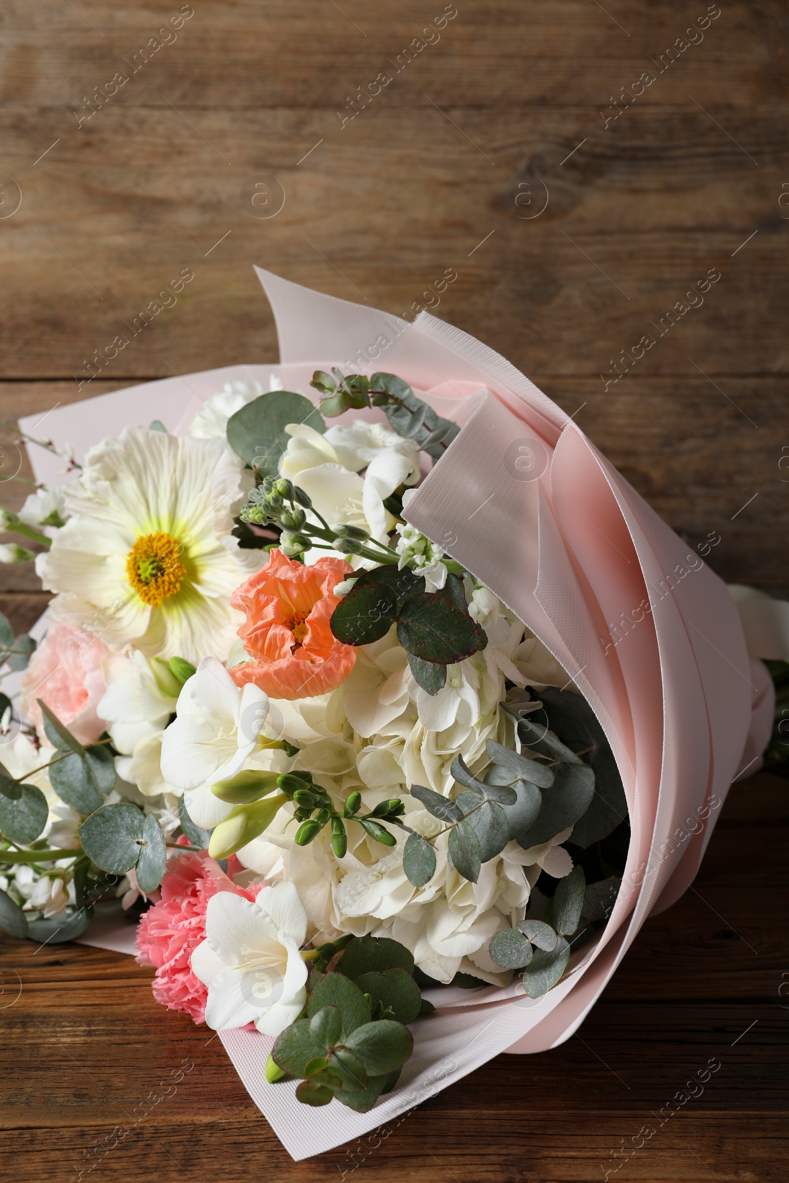 Photo of Bouquet of beautiful flowers on wooden table