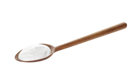 Spoon with creamy yogurt on white background