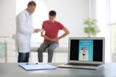 Photo of Laptop with picture of urogenital system and blurred people on background