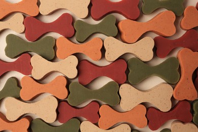 Photo of Flat lay composition with many bone shaped vitamins for pets on beige background