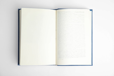 Photo of Open book on white background, top view. Space for text