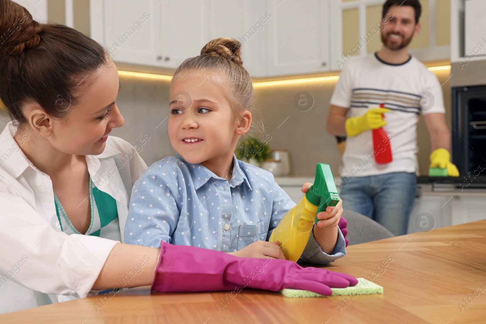 Photo of Spring cleaning. Happy family tidying up kitchen together