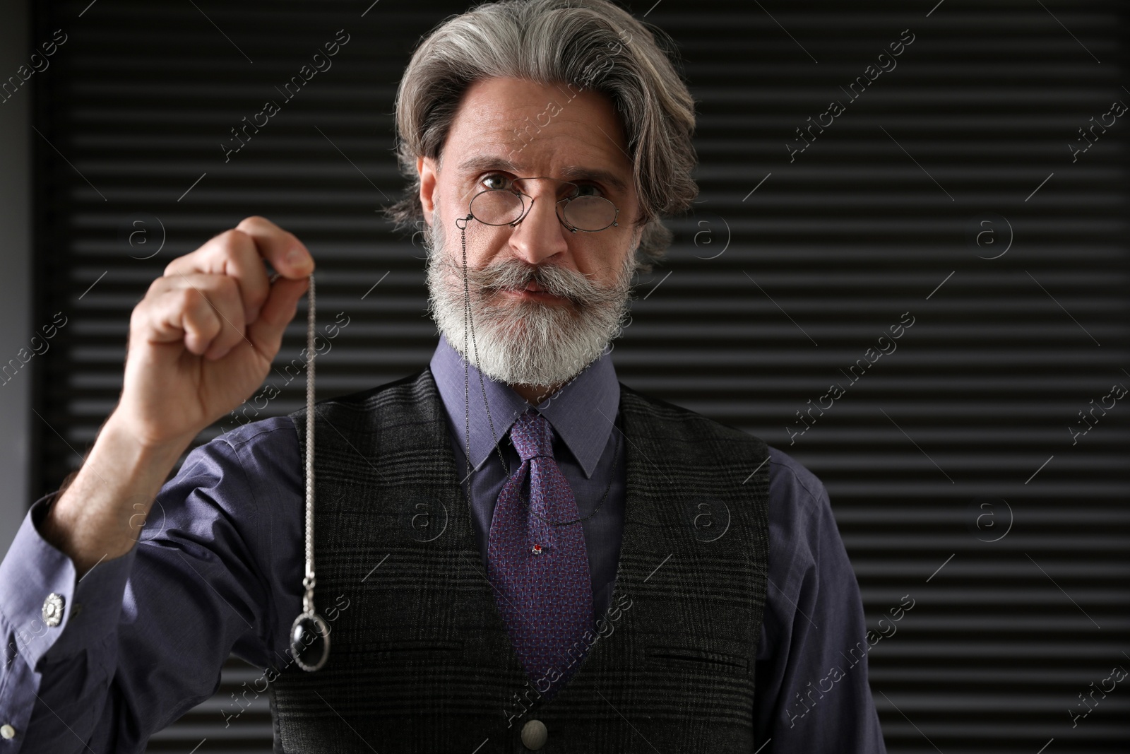 Photo of Psychotherapist with pendulum in office. Hypnotherapy session
