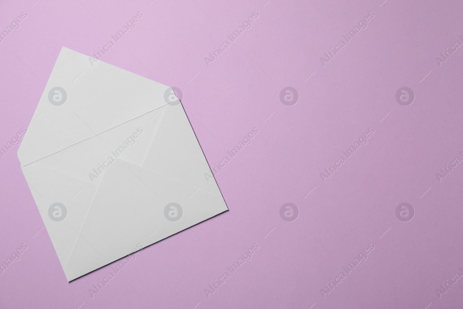 Photo of Letter envelope on violet background, top view. Space for text