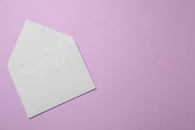 Photo of Letter envelope on violet background, top view. Space for text