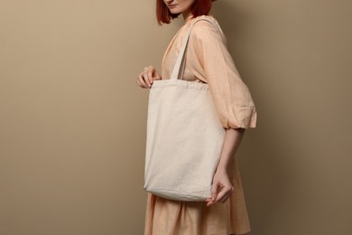 Photo of Woman with eco bag on beige background, closeup. Space for text