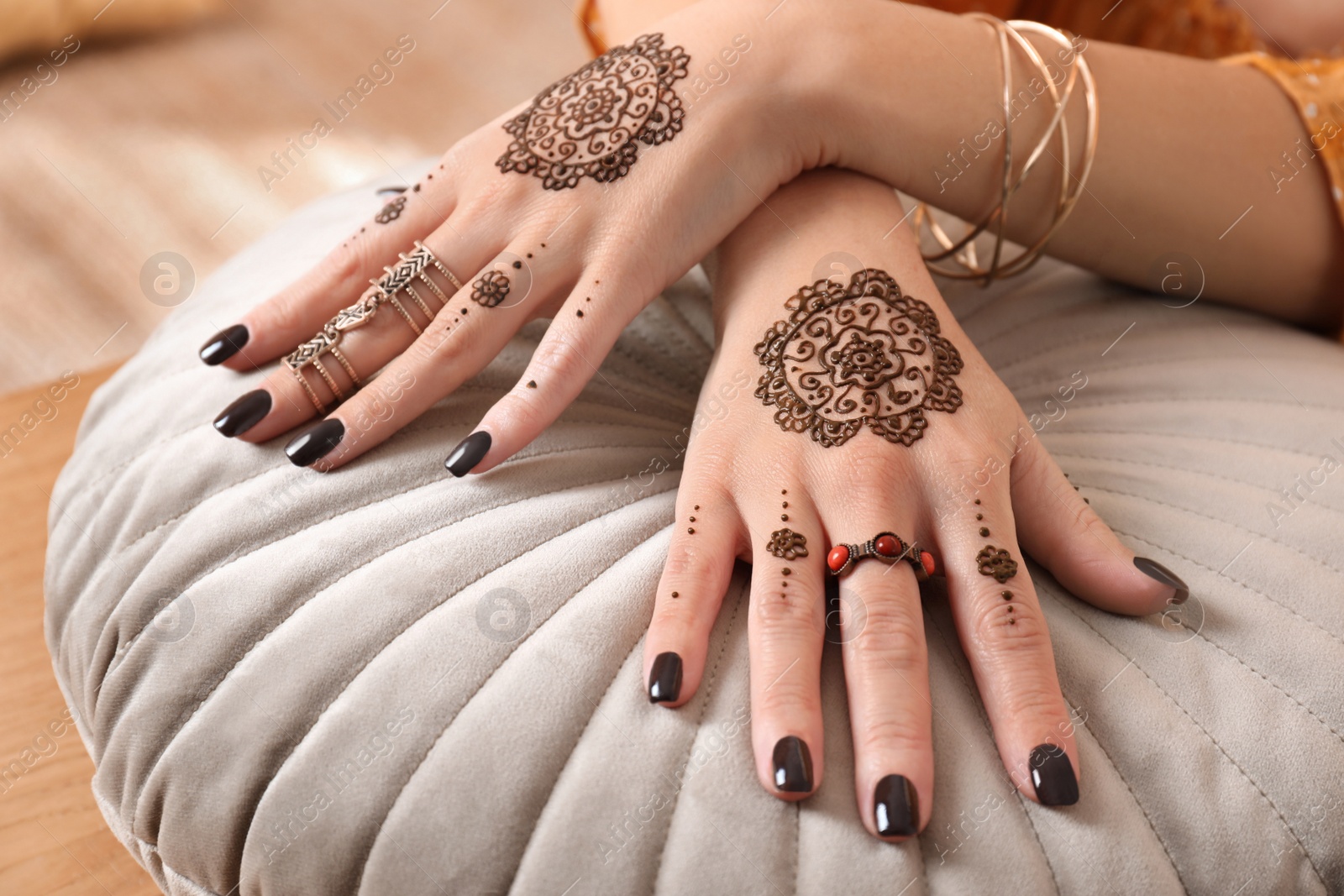 Photo of Woman with henna tattoos on hands, closeup. Traditional mehndi ornament