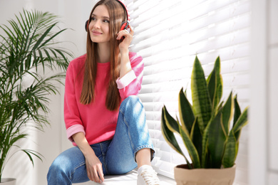 Photo of Woman listening to audiobook on window sill