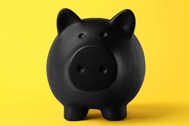 Photo of Ceramic piggy bank on yellow background, closeup. Financial savings