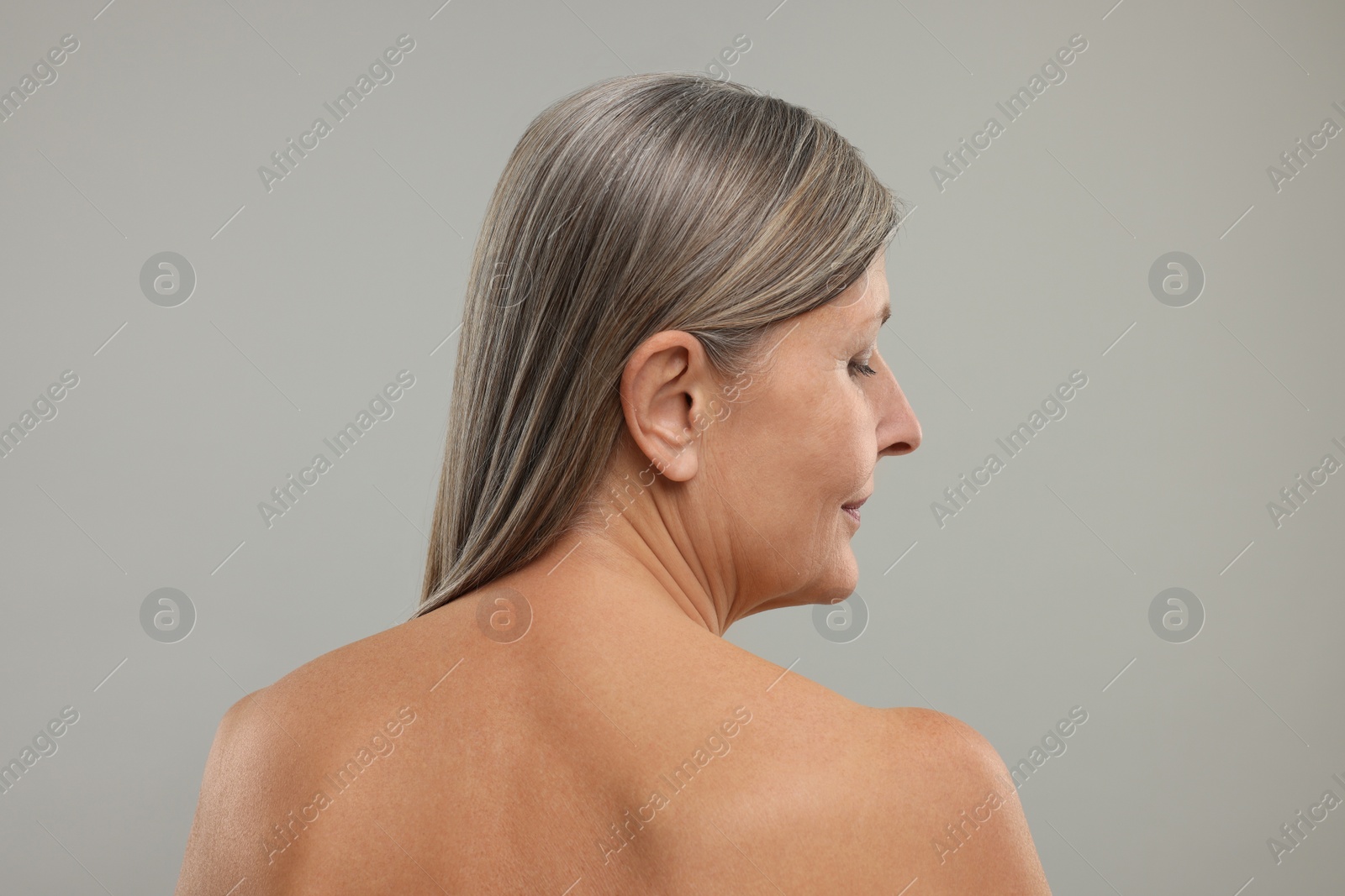 Photo of Beautiful woman with healthy skin on grey background, back view