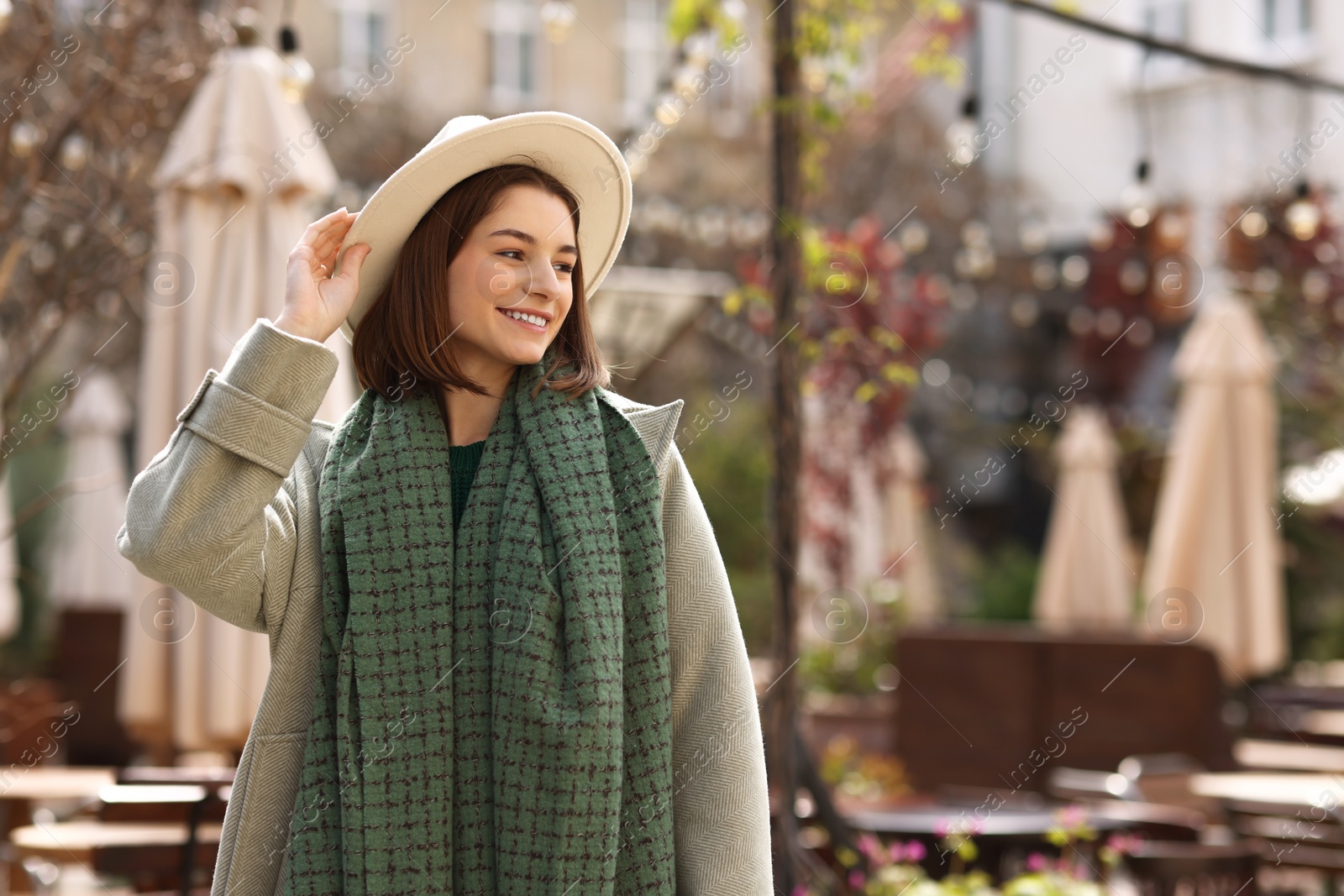 Photo of Beautiful woman in warm scarf and hat outdoors