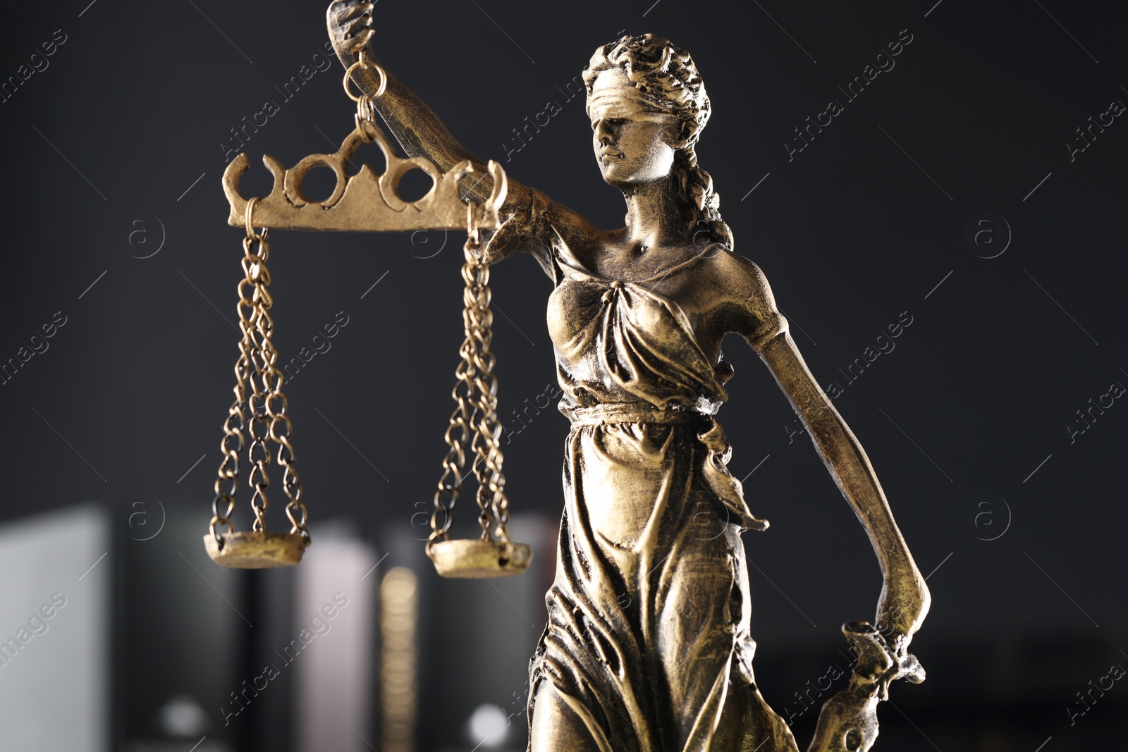 Photo of Statue of Lady Justice on dark background, closeup. Symbol of fair treatment under law