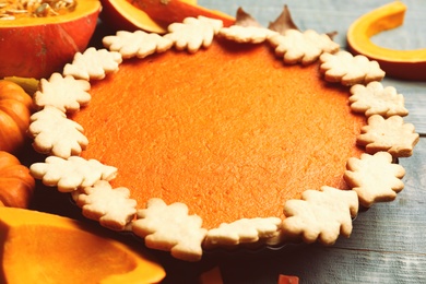 Photo of Delicious homemade pumpkin pie on blue wooden table, closeup