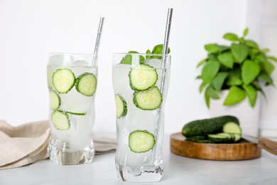 Photo of Tasty fresh cucumber water on white table
