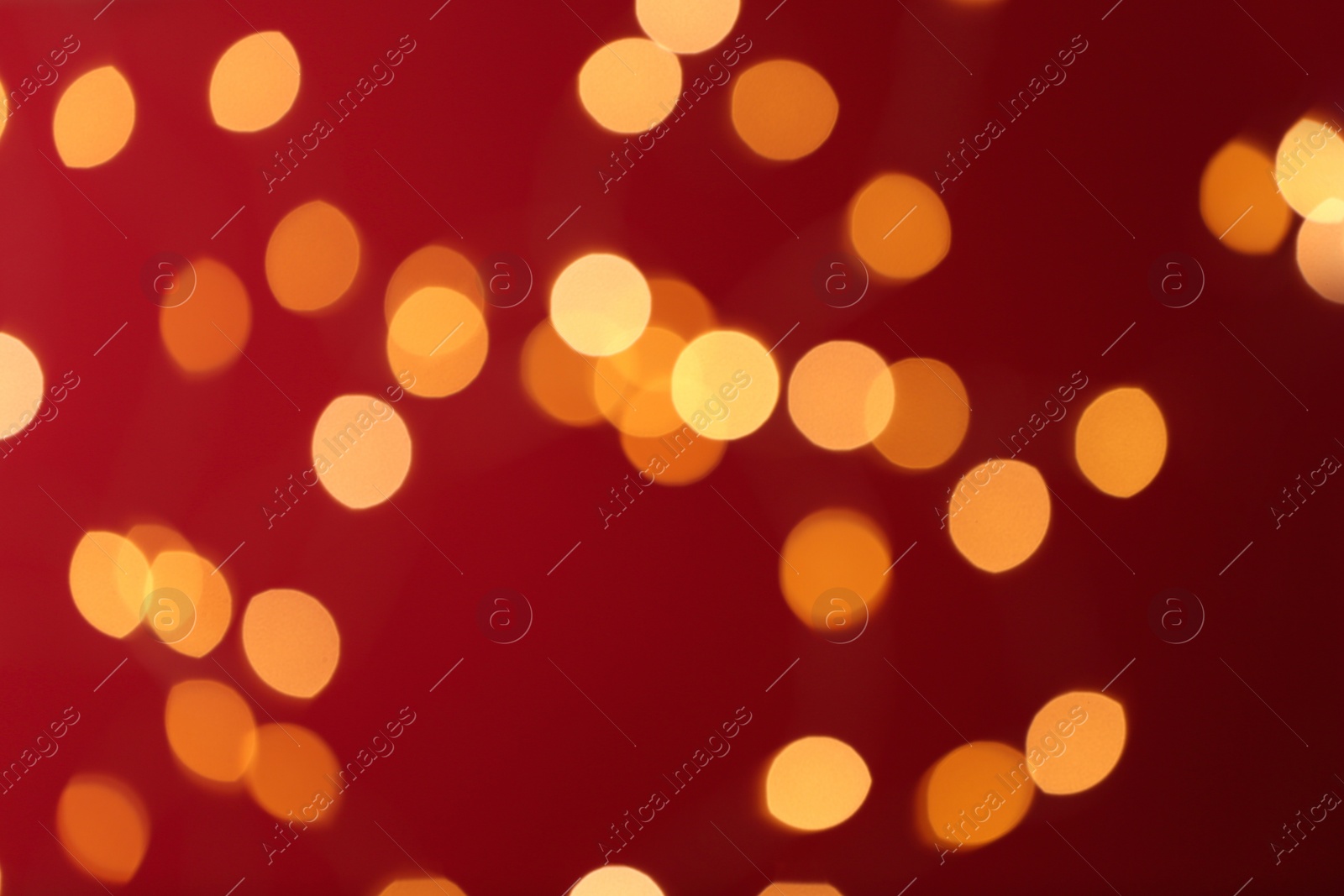 Photo of Blurred view of festive lights on red background. Bokeh effect