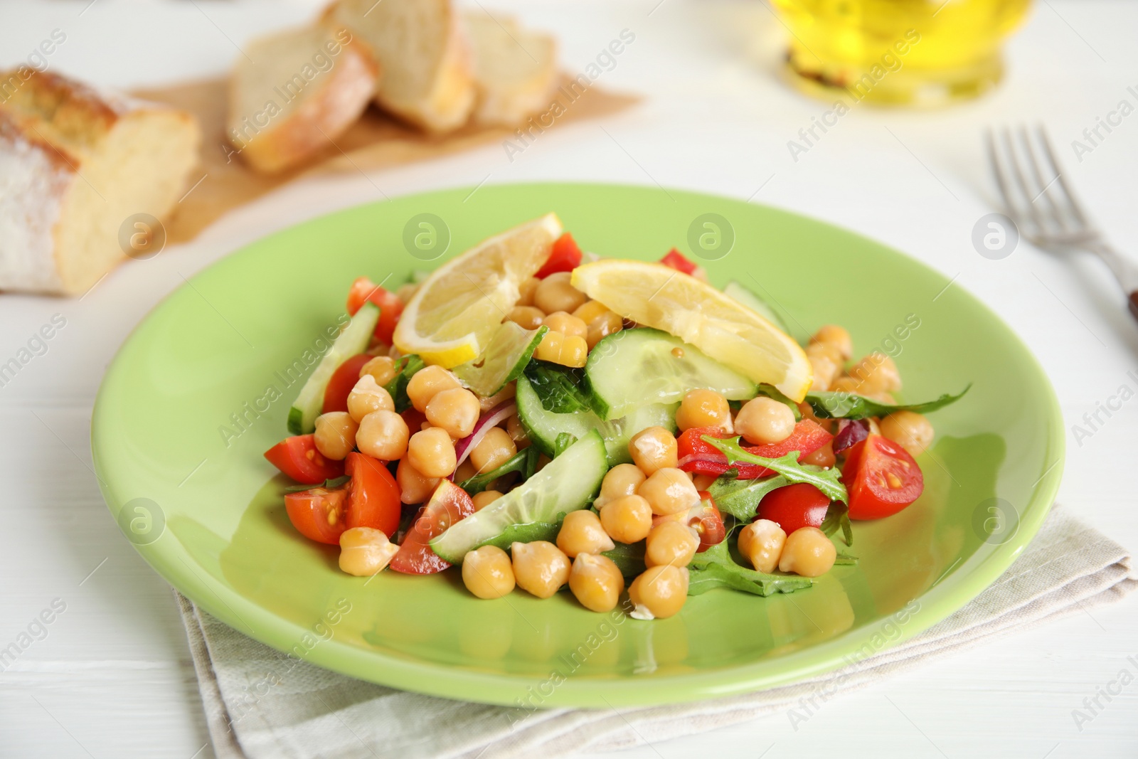 Photo of Delicious fresh chickpea salad on white wooden table