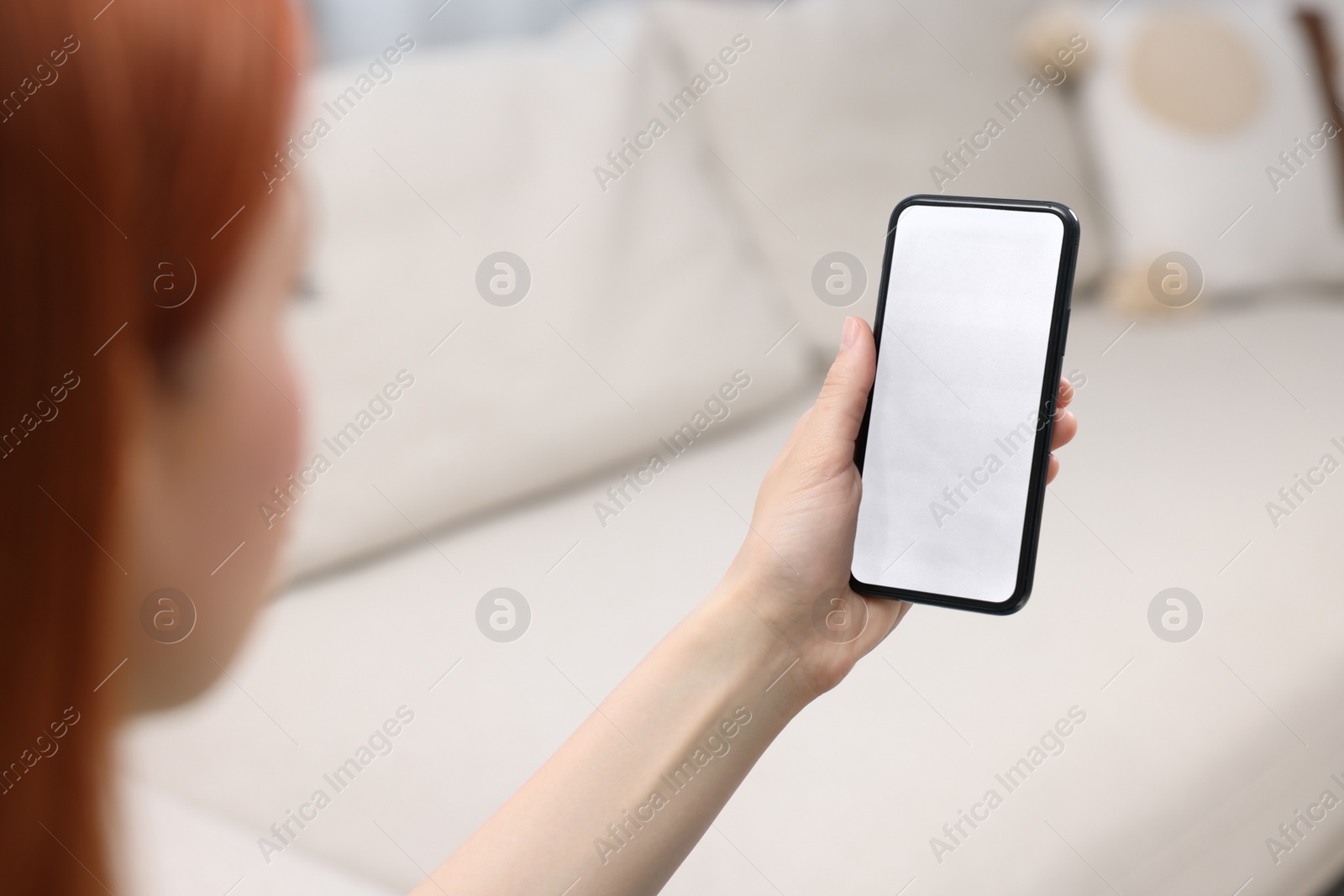 Photo of Woman using mobile phone indoors, closeup view