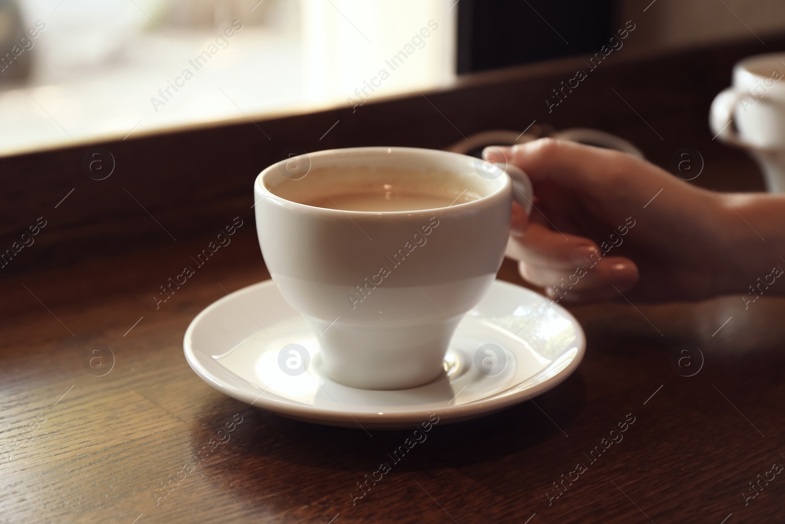 Photo of Woman with cup of fresh aromatic coffee at table