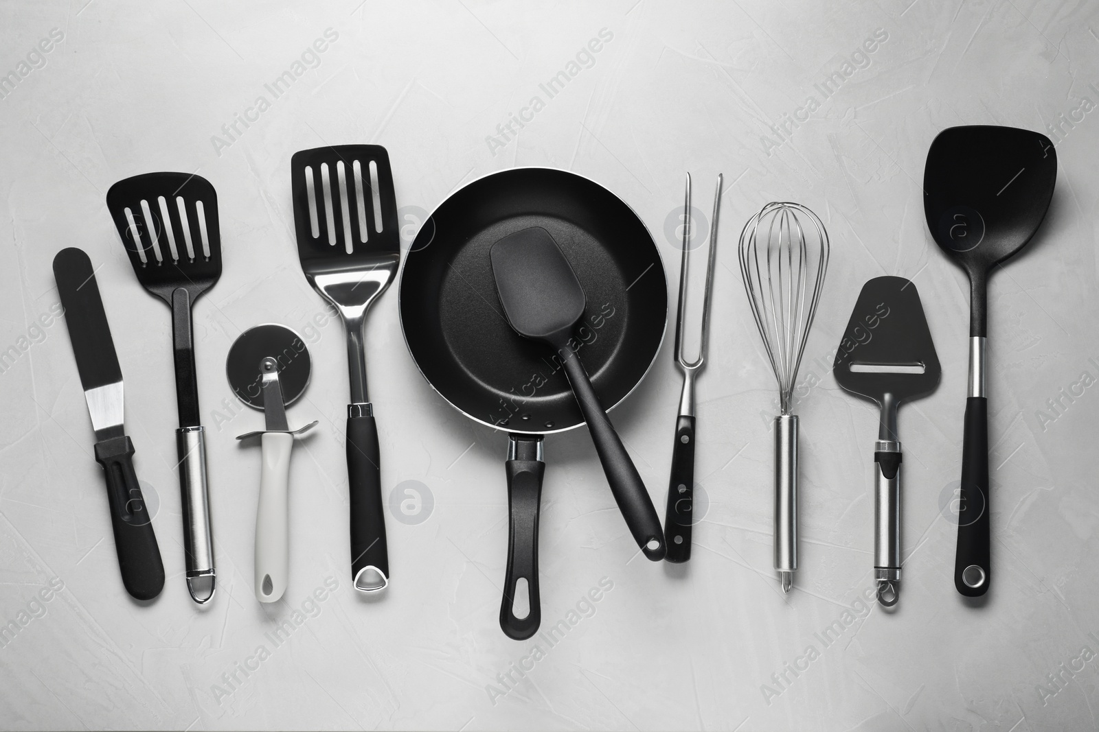 Photo of Different spatulas and other kitchen utensils on grey background, flat lay