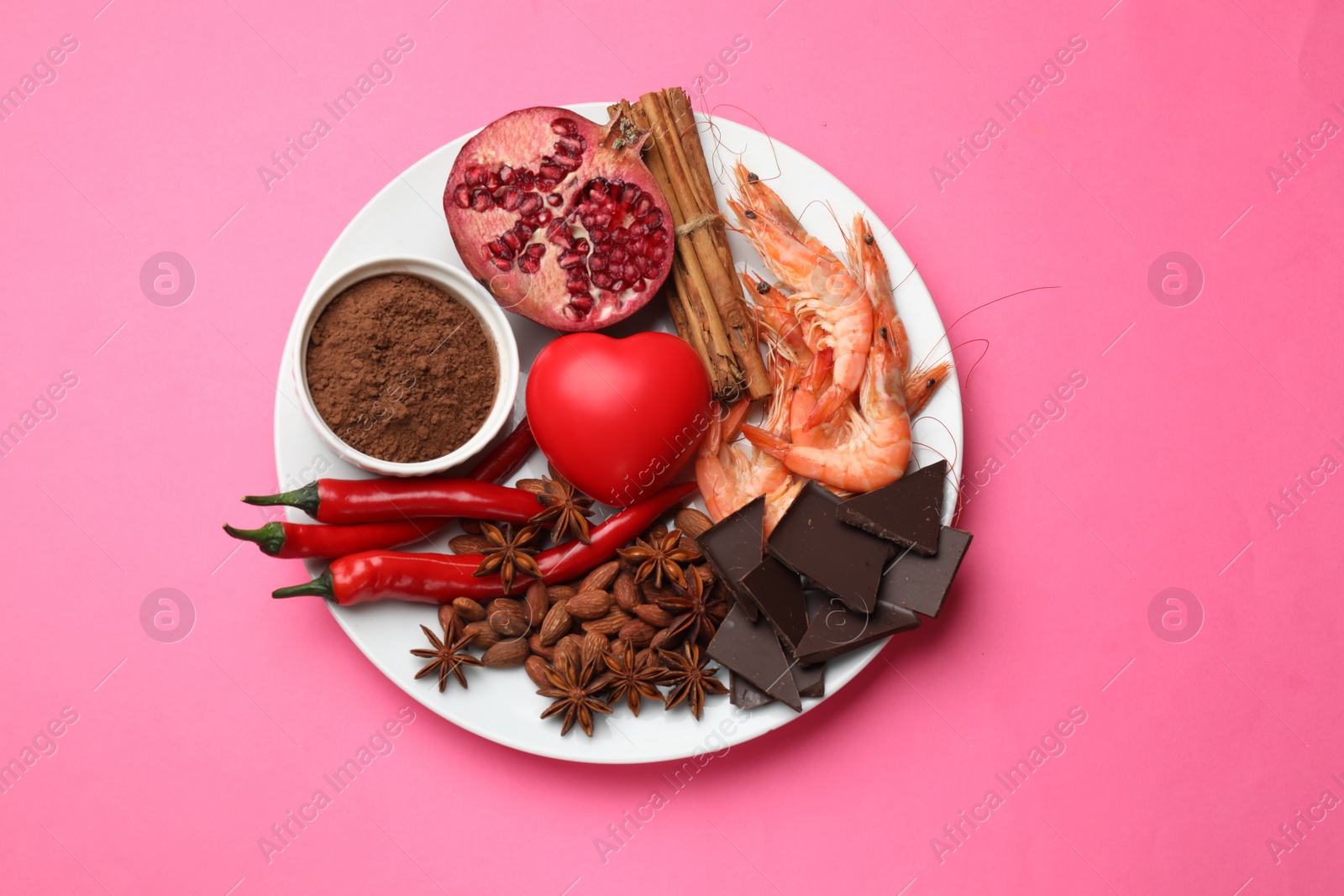 Photo of Natural aphrodisiac. Different products and heart model on pink background, top view