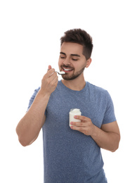 Photo of Happy young man eating tasty yogurt on white background
