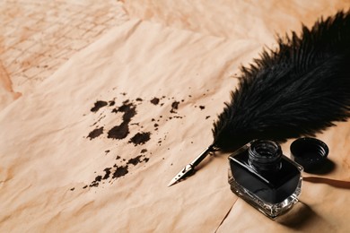 Open inkwell and lush feather pen on vintage parchments. Space for text