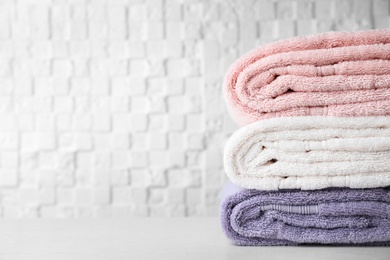 Photo of Stack of soft bath towels on table. Space for text