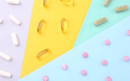 Many different vitamin pills on color background, flat lay