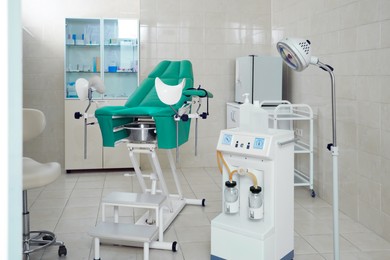 Examination room with gynecological chair and medical equipment in clinic