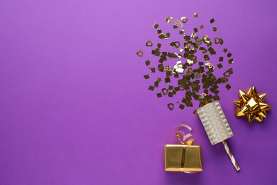 Flat lay composition of golden confetti and box on purple background, space for text