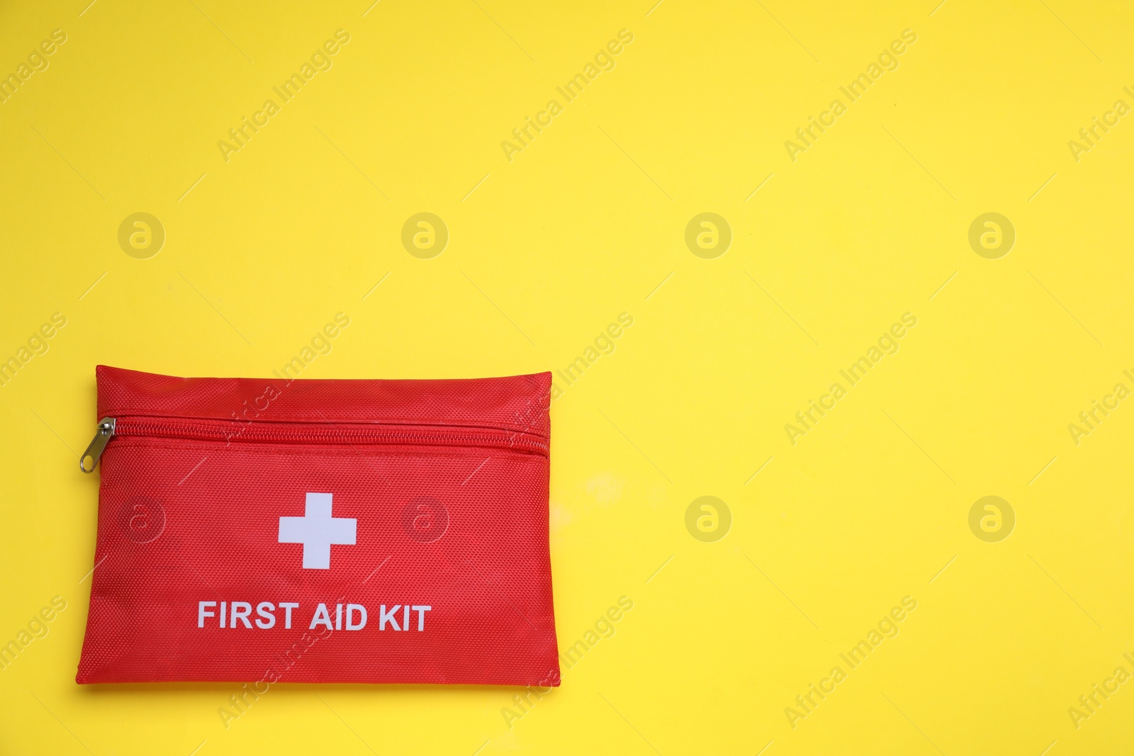 Photo of First aid kit on yellow background, top view and space for text