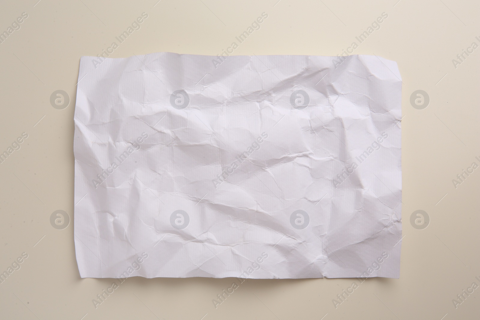 Photo of Sheet of crumpled parchment paper on beige background, top view