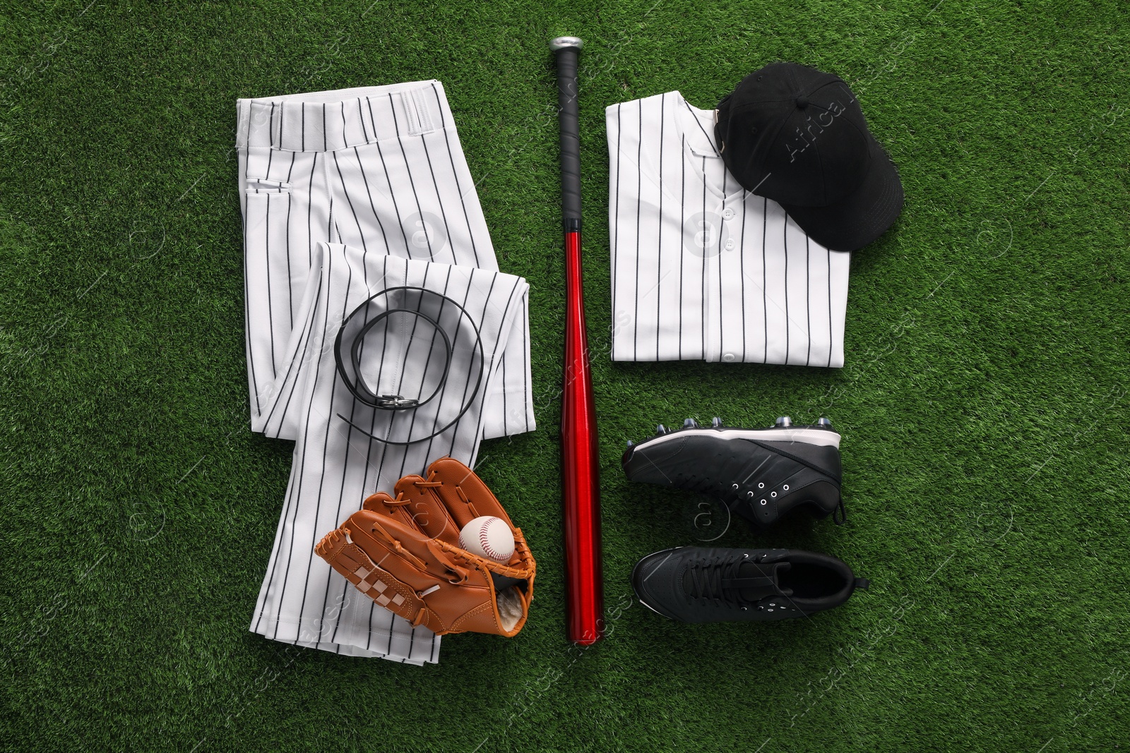 Photo of Flat lay composition with baseball equipment on artificial grass