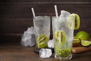 Photo of Glass of refreshing drink with kiwi on table, closeup. Space for text