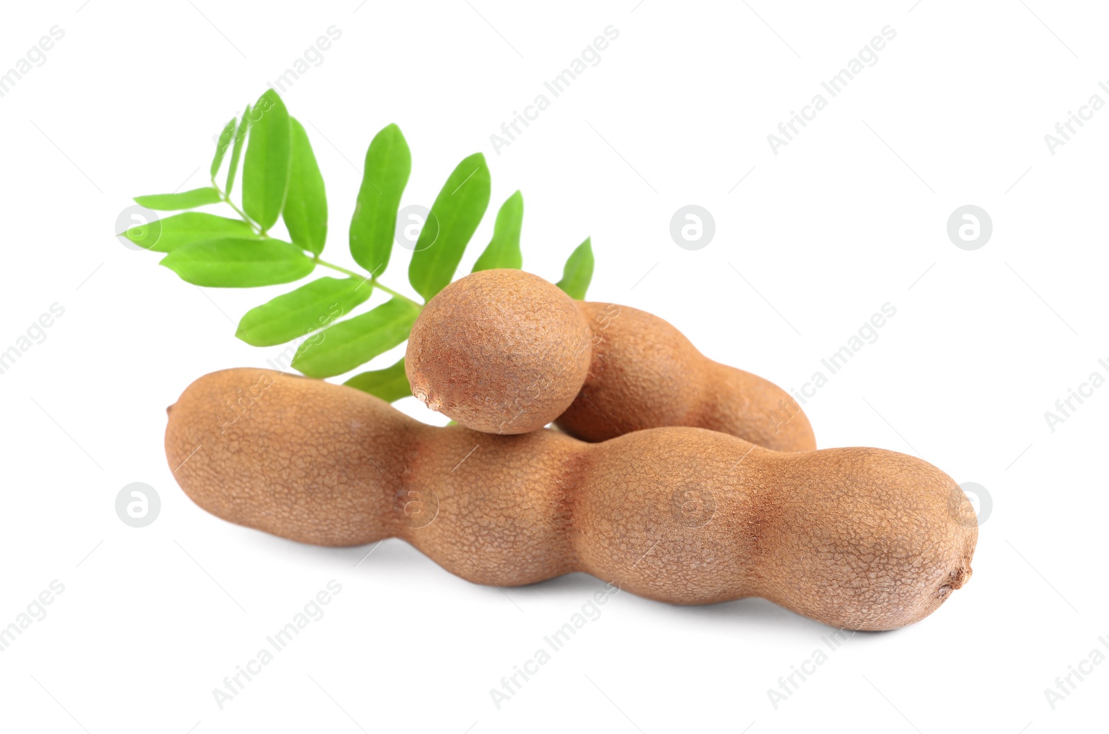 Photo of Delicious ripe tamarinds with leaves on white background. Exotic fruit