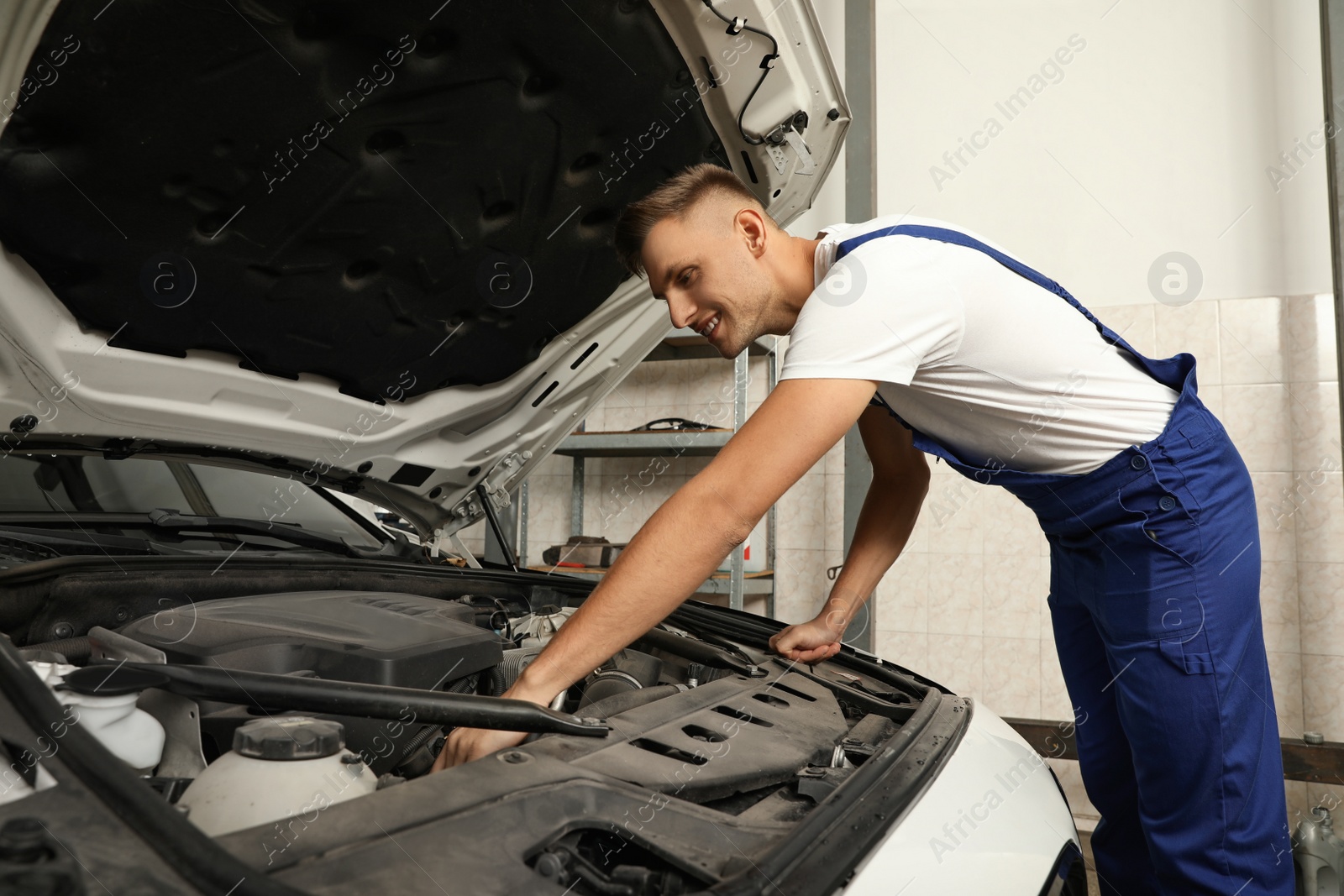 Photo of Professional mechanic checking modern car at automobile repair shop