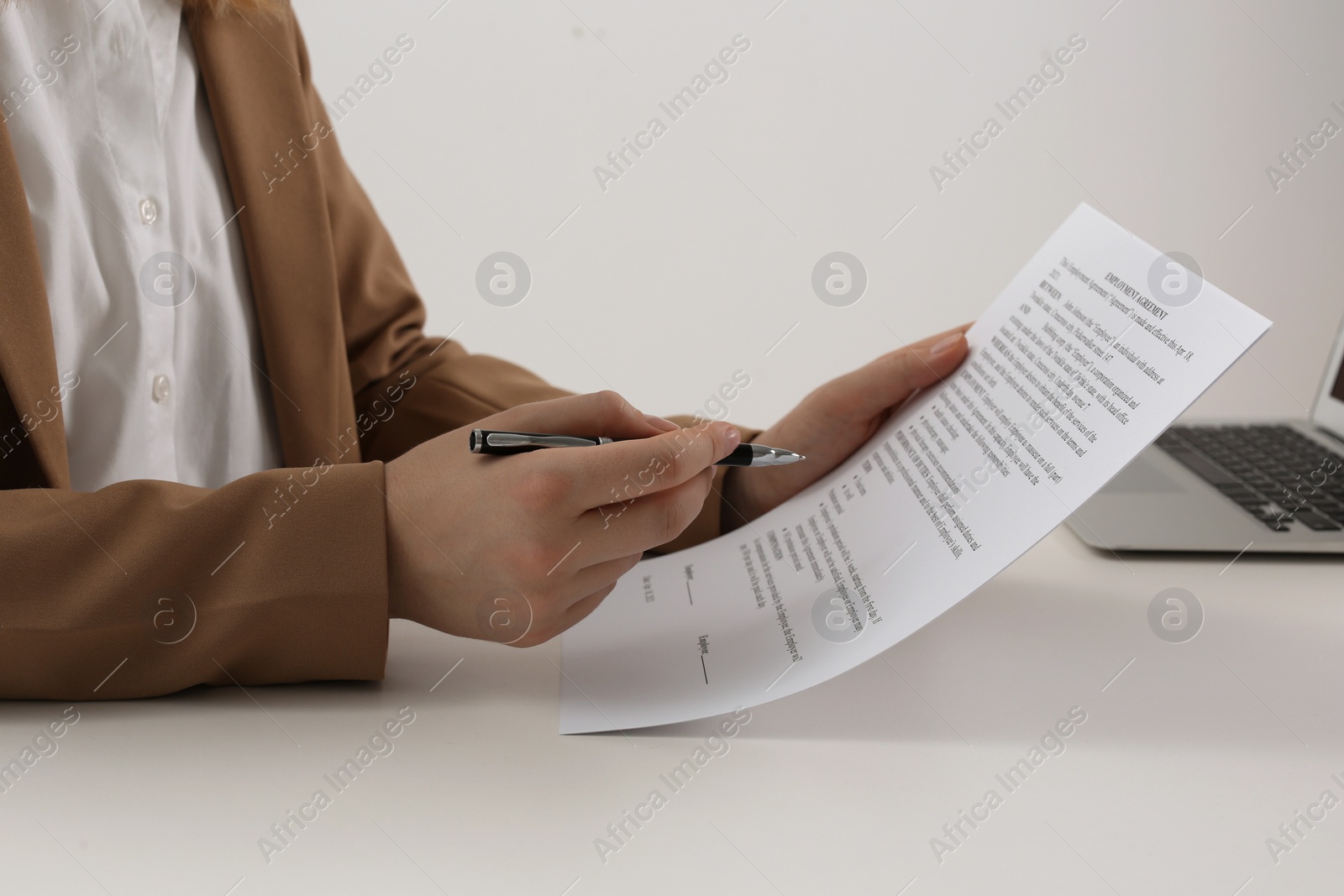 Photo of Businesswoman working with contract at white table, closeup