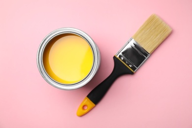 Photo of Open can with paint and brush on color background, top view
