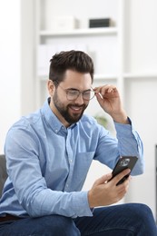 Handsome young man using smartphone in office