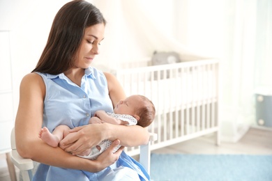 Photo of Young woman with her newborn baby at home. Space for text