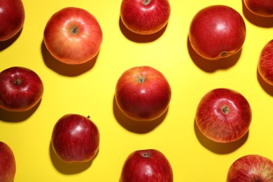 Photo of Ripe red apples on yellow background, flat lay
